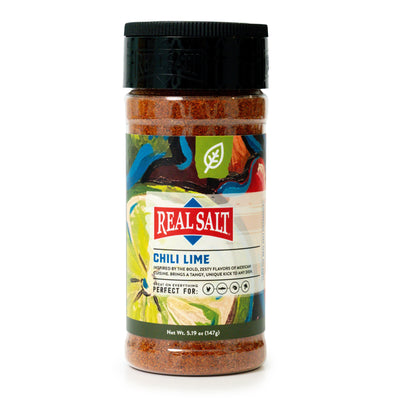 A jar of Real Salt Chili Lime seasoning displays its vibrant label against a white background. 
