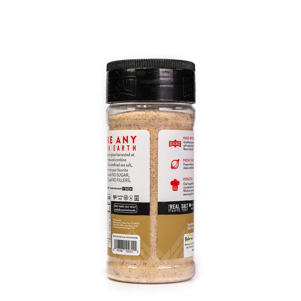Clear shaker of Real Salt's Onion Salt, showcasing the fine-ground texture of the seasoning blend.